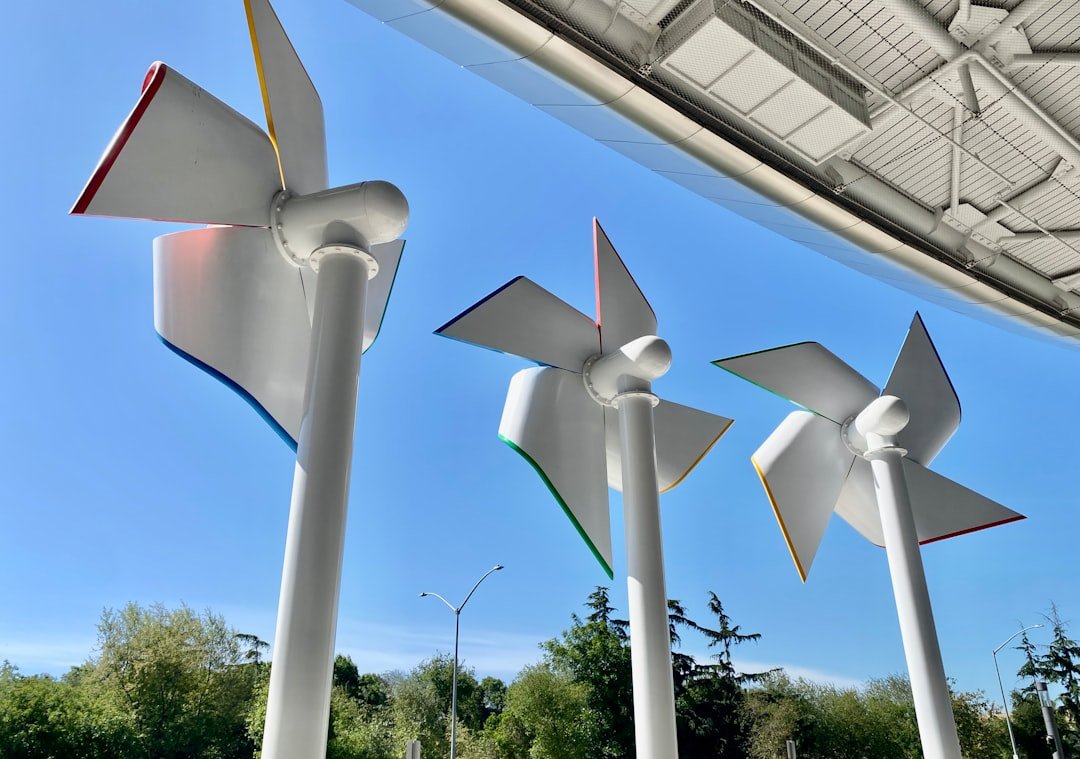 three-white-wind-turbines-against-a-blue-sky-t4s2x1ymusc